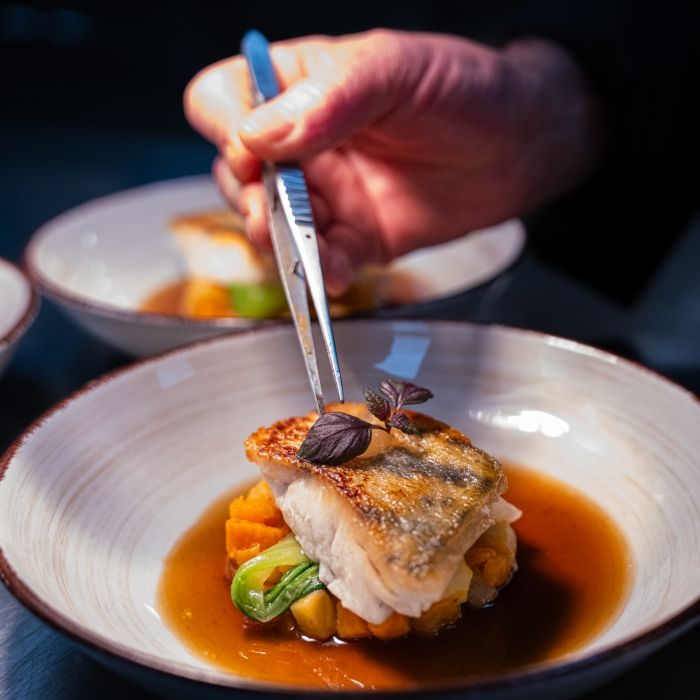 Dressage d’un plat gastronomique à base de poisson et légumes d’hiver au restaurant Les Bas Rupts