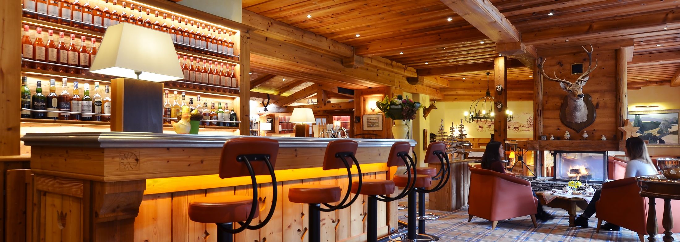 Bar de l’hôtel Les Bas Rupts à Gérardmer avec cheminée, fauteuils et ambiance lounge dans les Vosges.